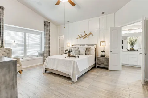 a white bed sitting in a room next to a window