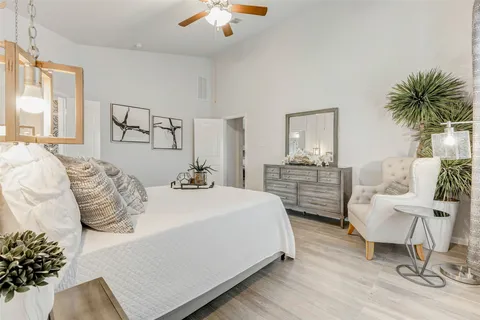 a spacious bedroom with a bed a couch and dresser