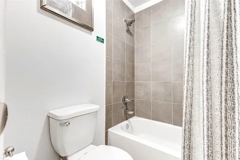 a white toilet sitting next to a bath tub