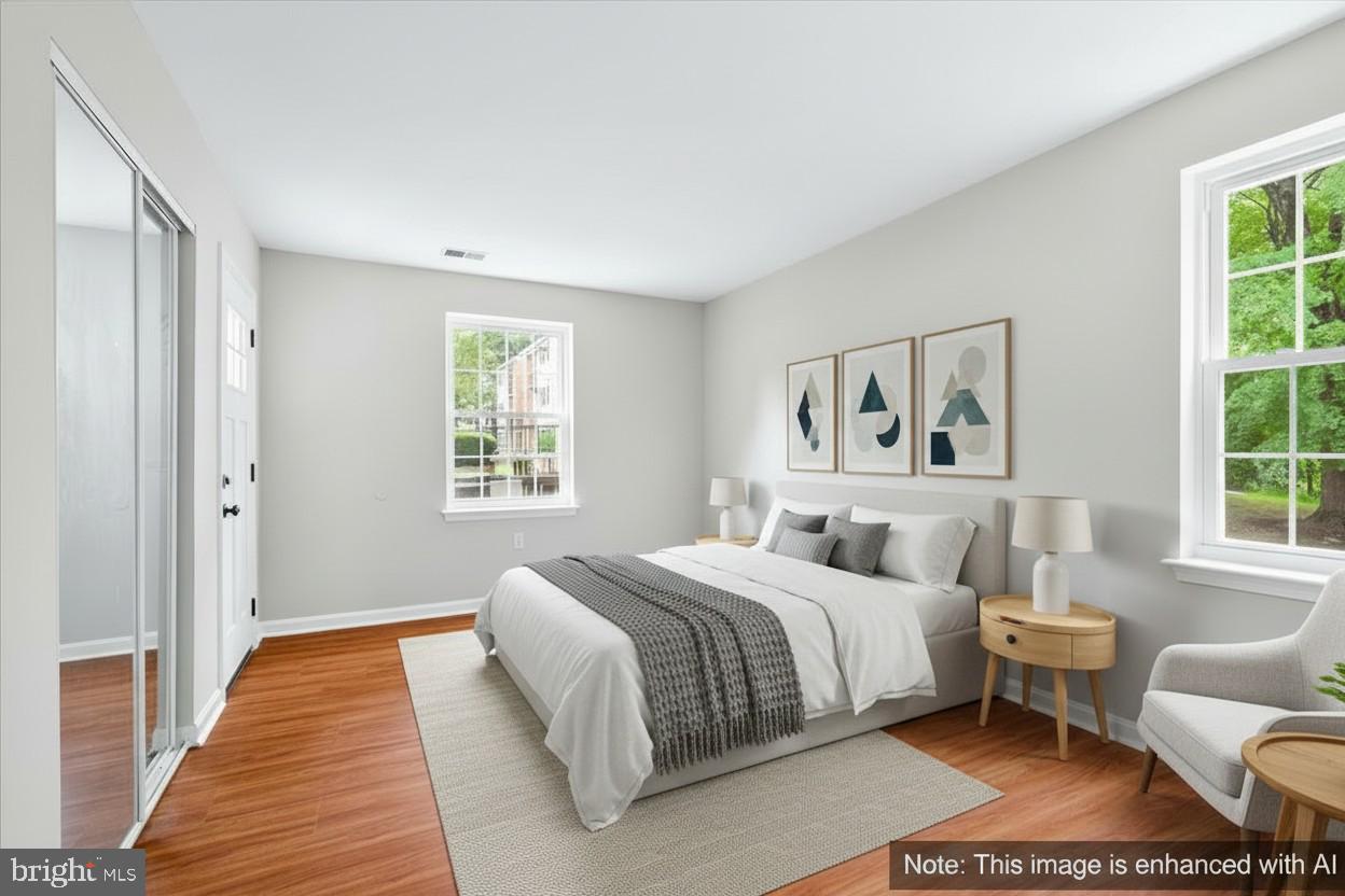 18334 Streamside Drive, Unit 101 Gaithersburg, MD 20879 - Photo 16 of 29 a bedroom with a bed wooden floor and window