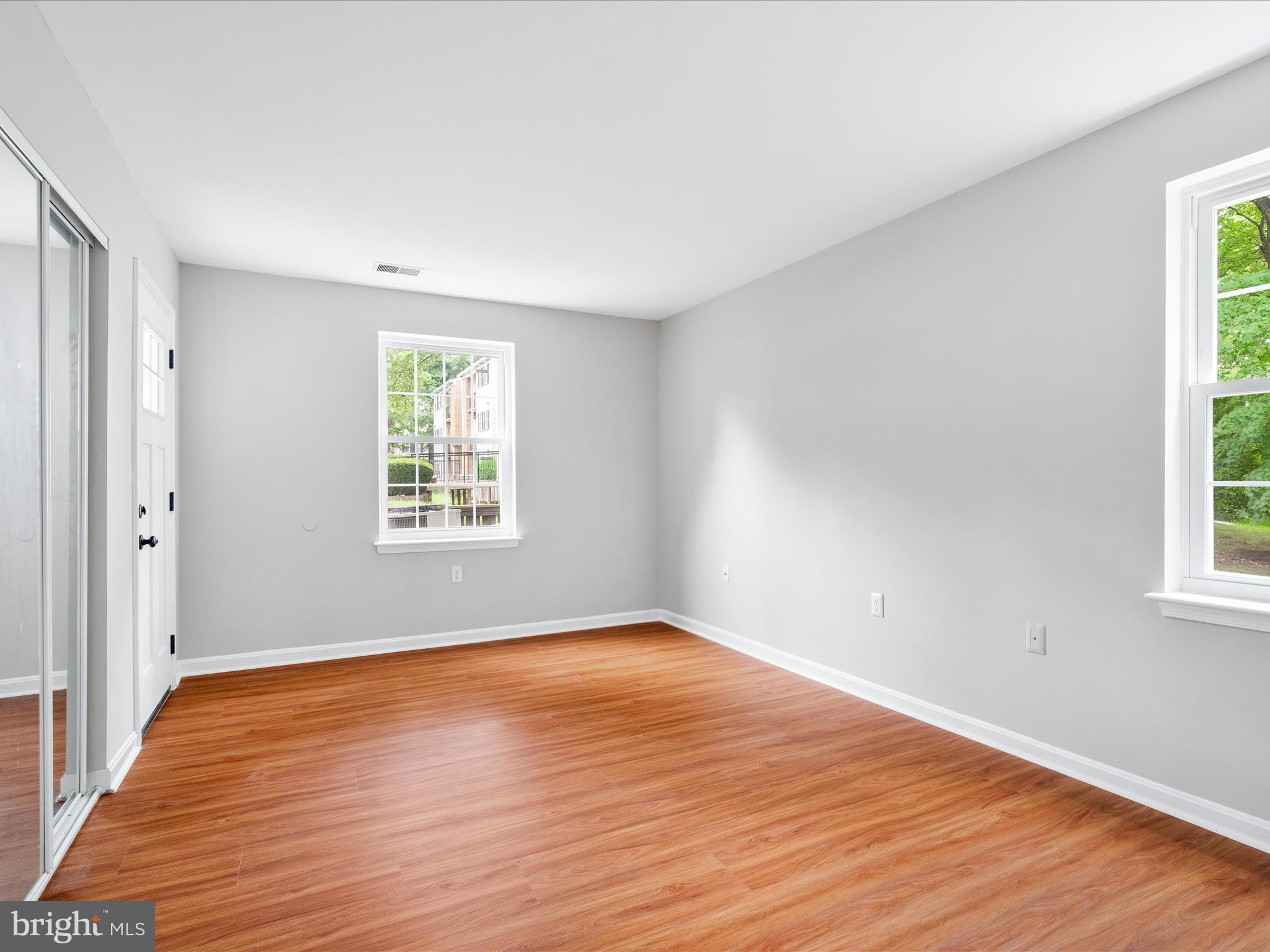 18334 Streamside Drive, Unit 101 Gaithersburg, MD 20879 - Photo 17 of 29 an empty room with wooden floor and windows