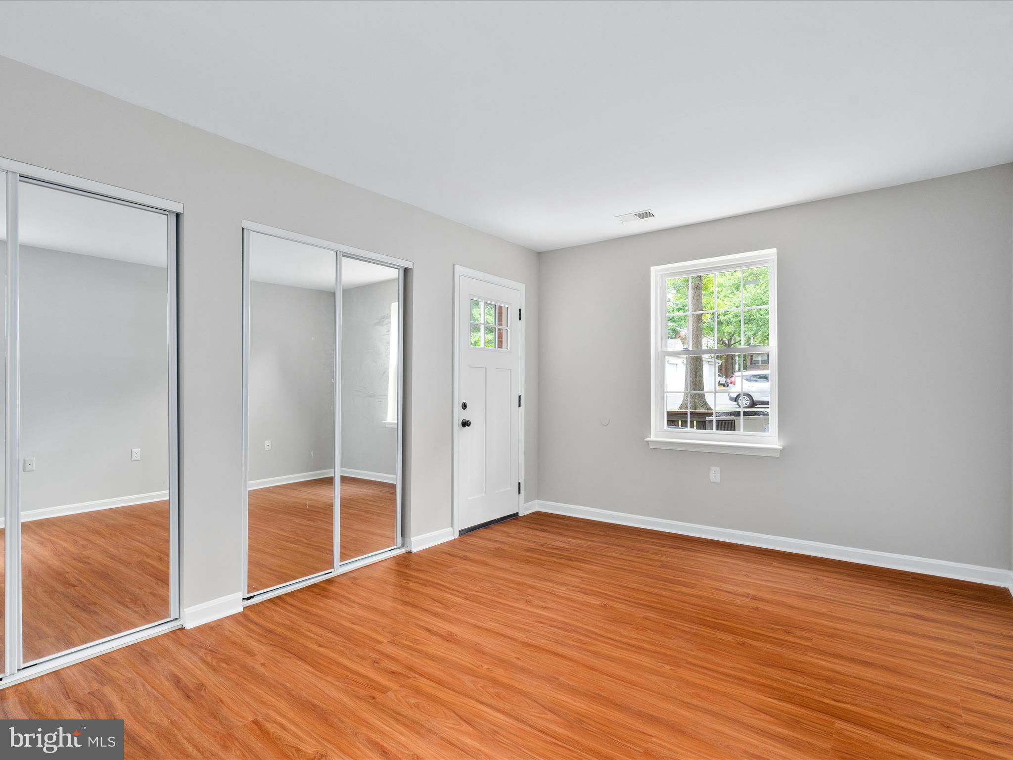 18334 Streamside Drive, Unit 101 Gaithersburg, MD 20879 - Photo 18 of 29 an empty room with wooden floor and windows
