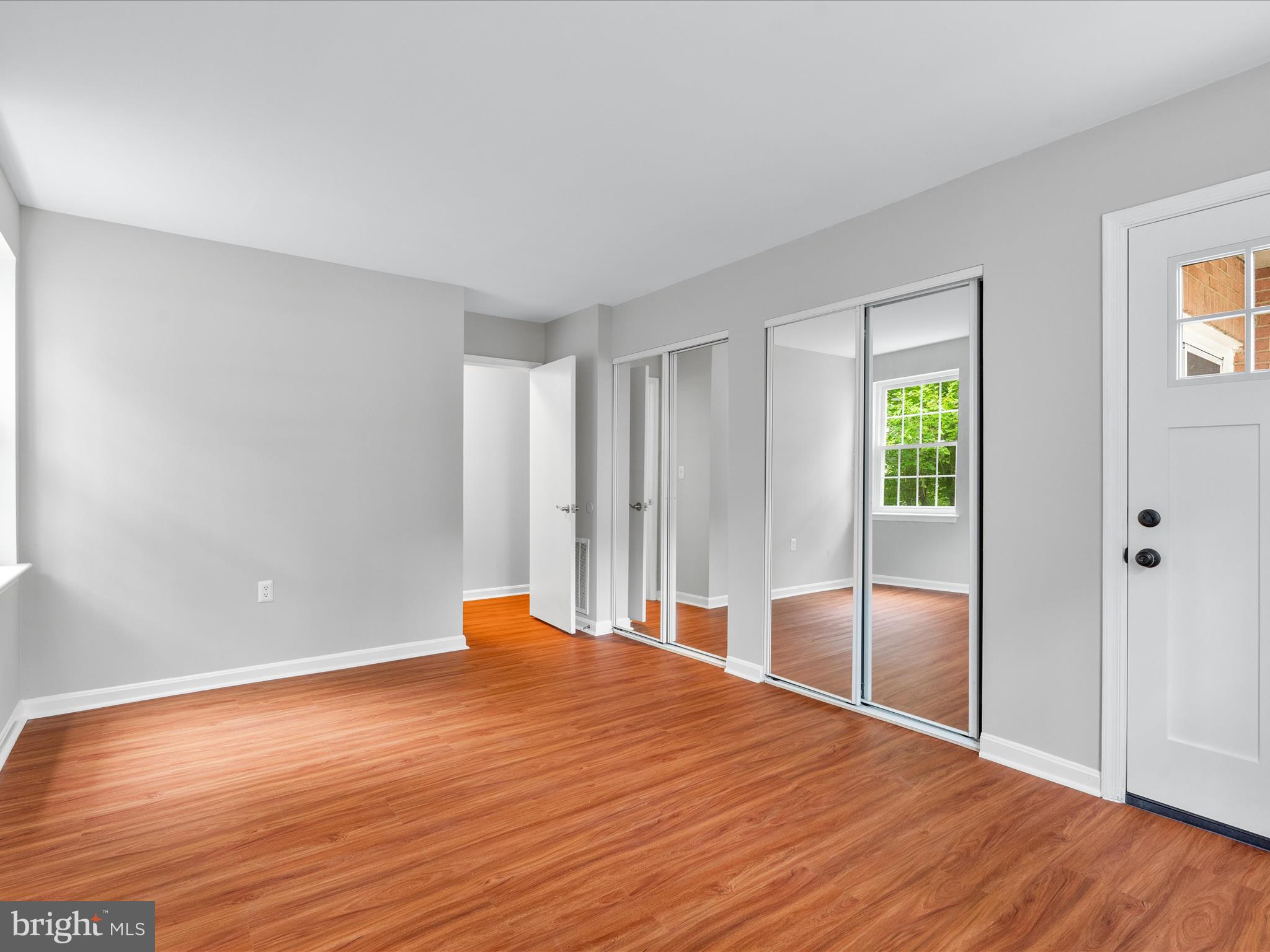 18334 Streamside Drive, Unit 101 Gaithersburg, MD 20879 - Photo 19 of 29 a room with wooden floor and window