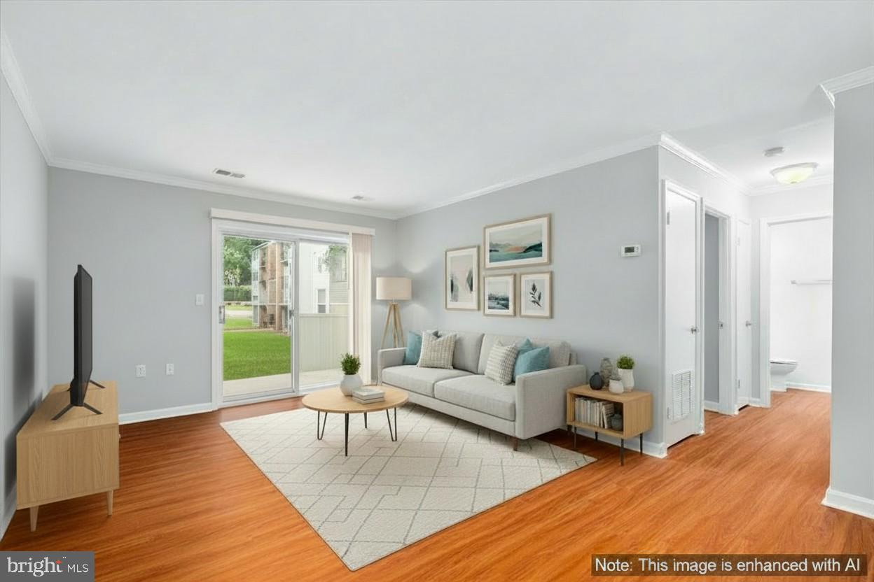 18334 Streamside Drive, Unit 101 Gaithersburg, MD 20879 - Photo 2 of 29 a living room with furniture a flat screen tv and a large window