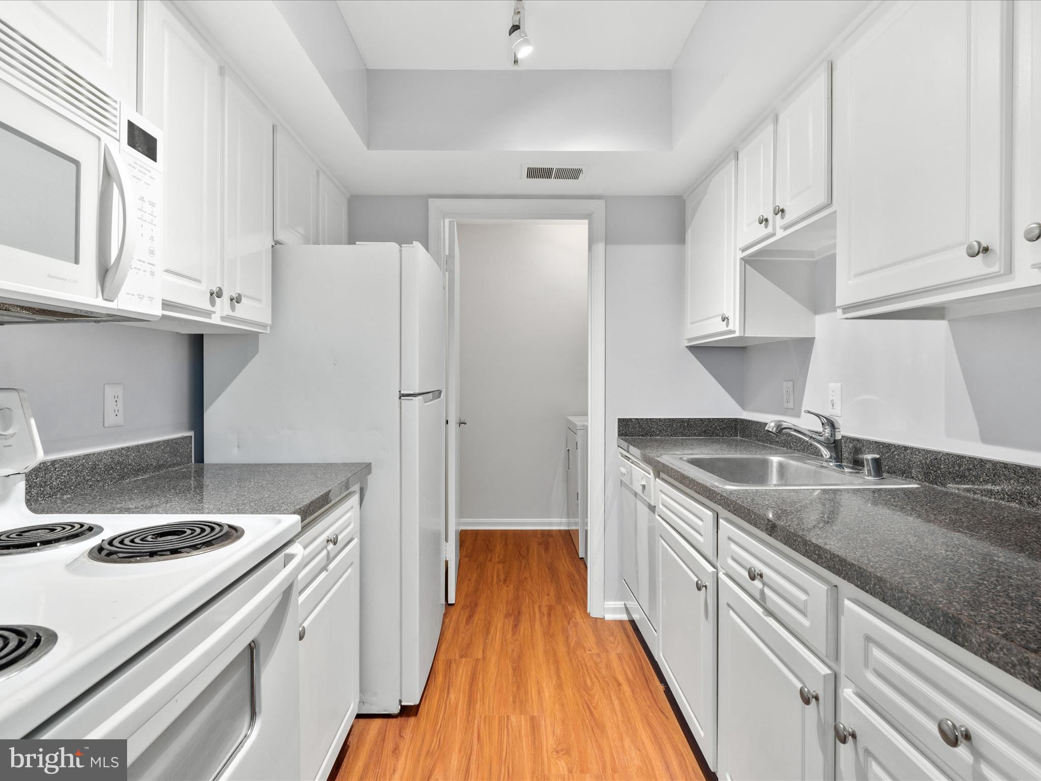 18334 Streamside Drive, Unit 101 Gaithersburg, MD 20879 - Photo 10 of 29 a kitchen with a sink a stove and refrigerator