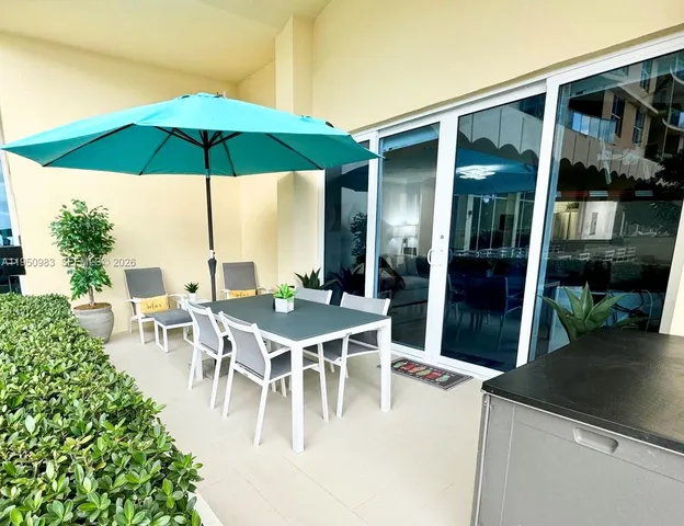 a view of a patio with a table and chairs under an umbrella