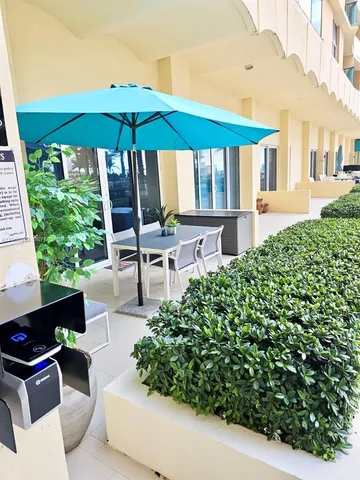 a patio with a table and chairs under an umbrella