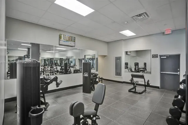 a room with gym equipment and refrigerator