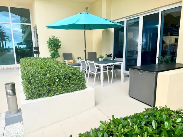 a view of a patio with table and chairs under an umbrella