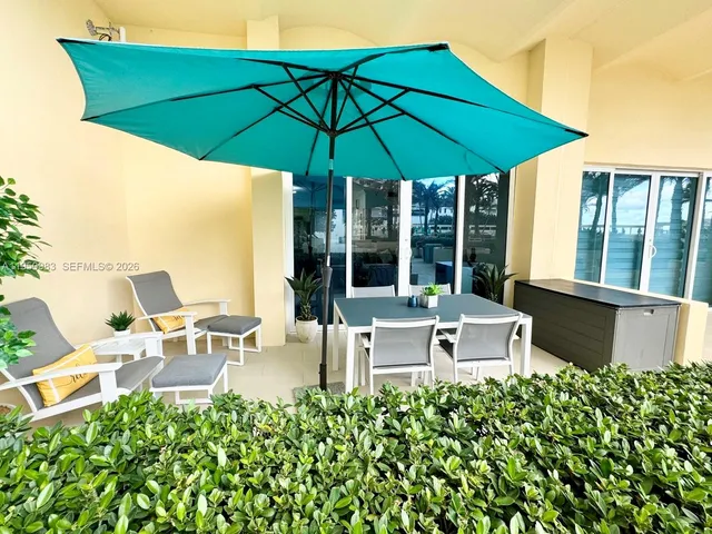 a view of a patio with chairs under an umbrella