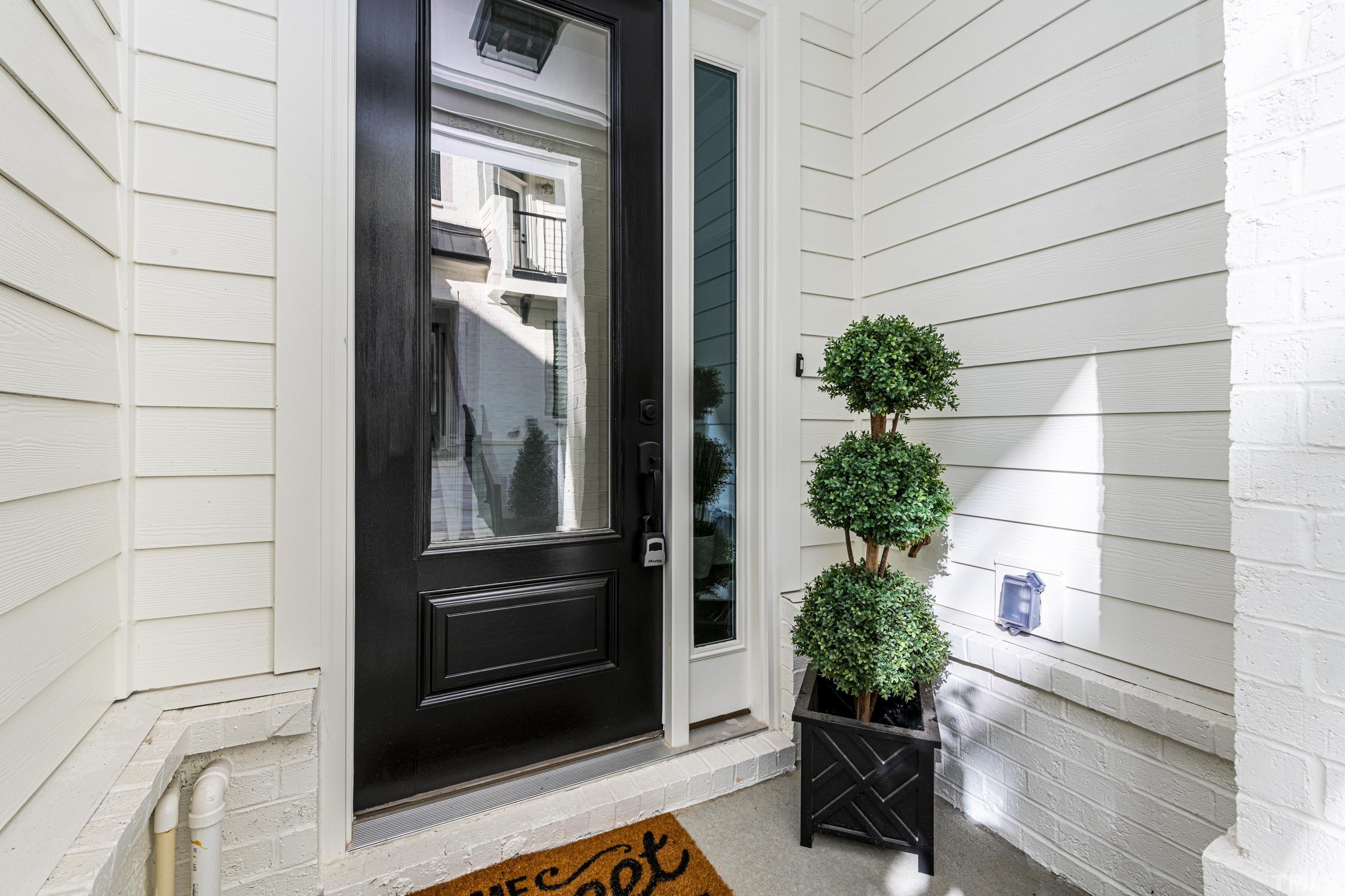 401 Bryan Pointe Drive, Unit 102 Raleigh, NC 27608 - Photo 2 of 30 a potted plant sitting in front of a door