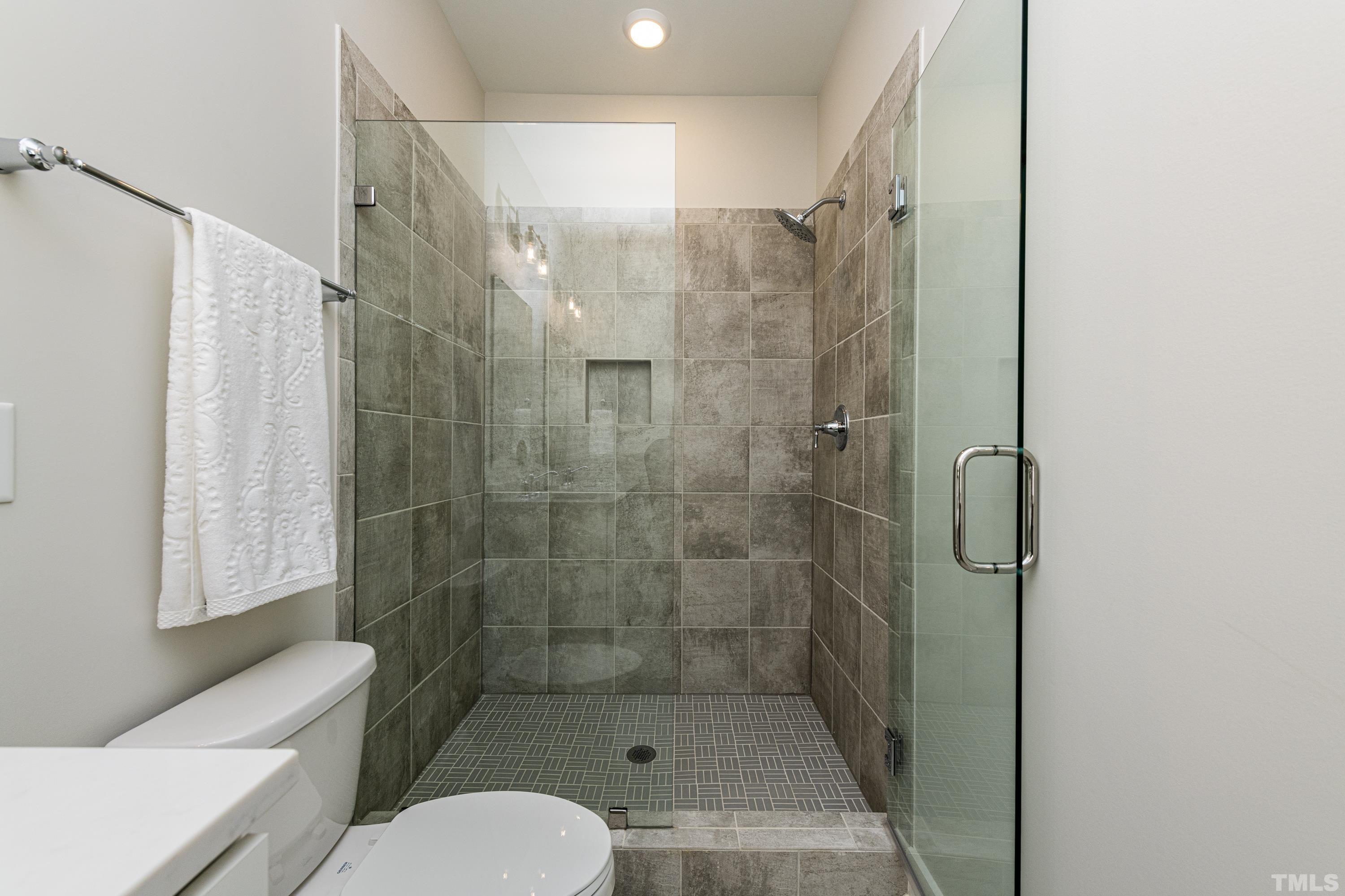 401 Bryan Pointe Drive, Unit 102 Raleigh, NC 27608 - Photo 24 of 30 a bathroom with a shower and toilet