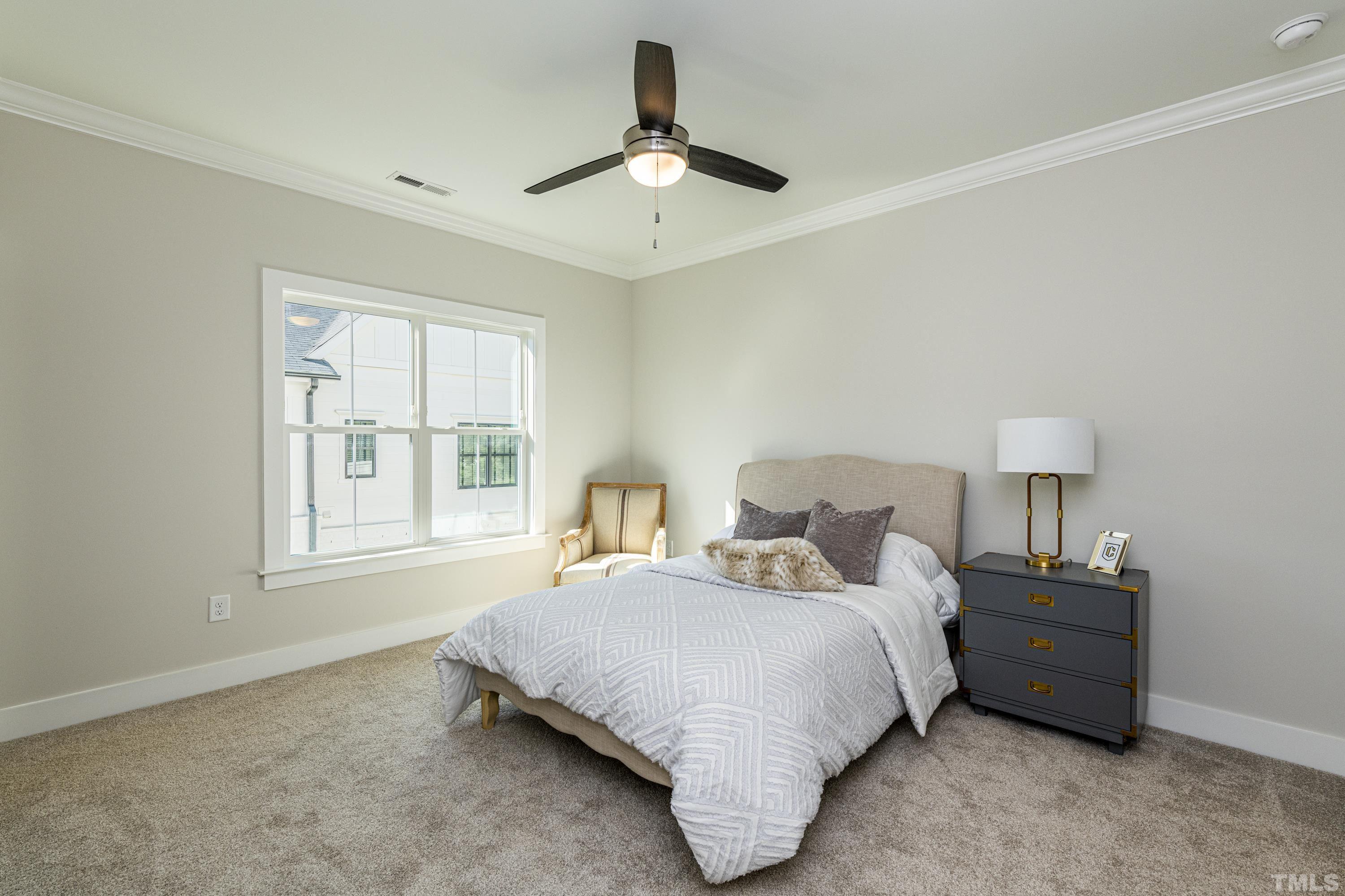 401 Bryan Pointe Drive, Unit 102 Raleigh, NC 27608 - Photo 25 of 30 a bedroom with a bed a chandelier and a window