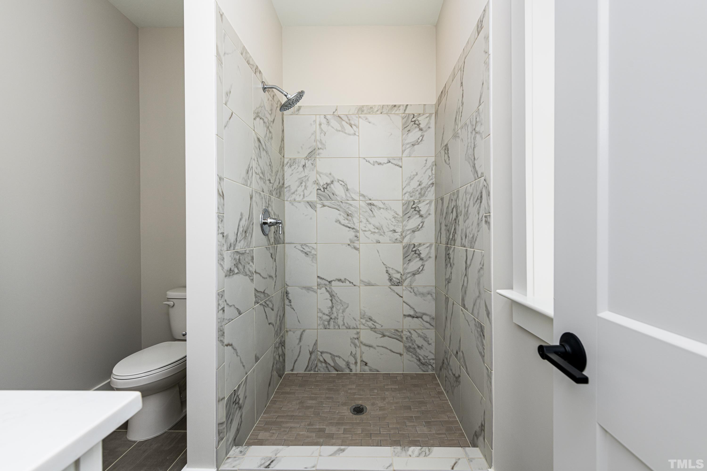401 Bryan Pointe Drive, Unit 102 Raleigh, NC 27608 - Photo 27 of 30 a bathroom with a shower and toilet