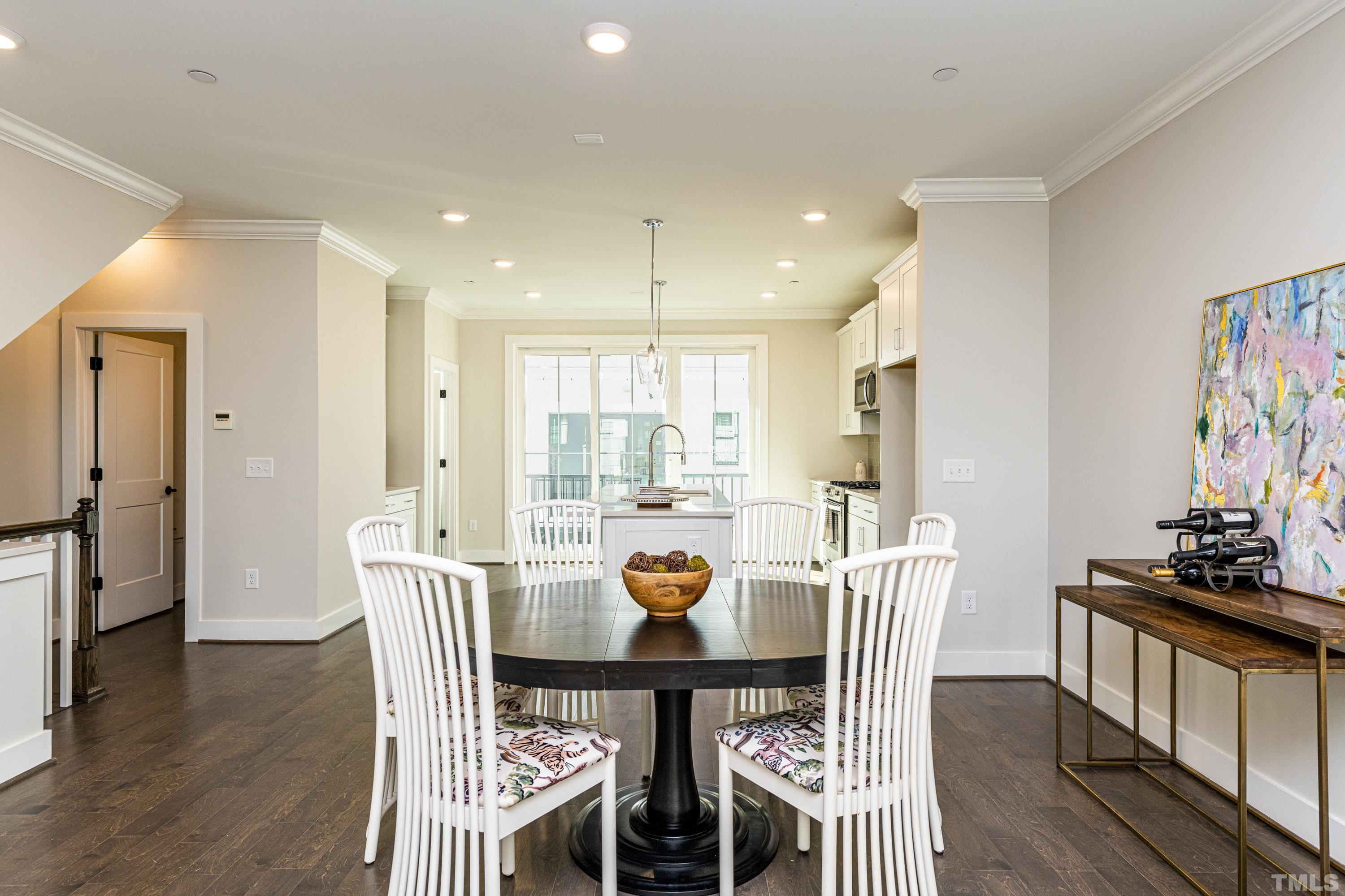 401 Bryan Pointe Drive, Unit 102 Raleigh, NC 27608 - Photo 10 of 30 a view of a dining room with furniture a rug and wooden floor