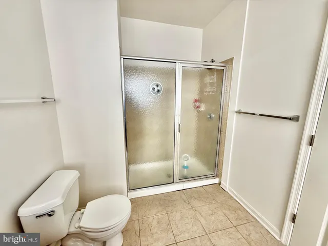 a bathroom with a granite countertop toilet a sink and shower