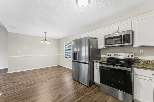 a kitchen with a stove a microwave and a refrigerator