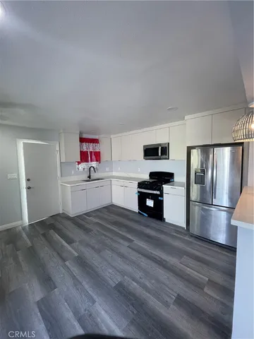 a kitchen with granite countertop a refrigerator and a sink