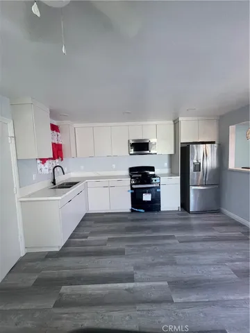 a kitchen with granite countertop a sink cabinets and stainless steel appliances
