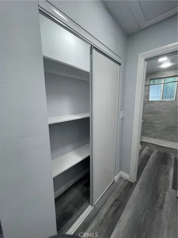 a hallway view with wooden floor and staircase