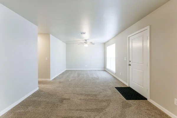 an empty room with windows and ceiling fan