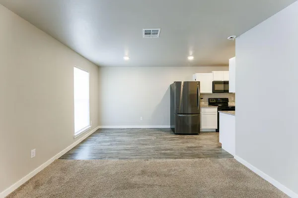 a kitchen with a refrigerator and wooden floor