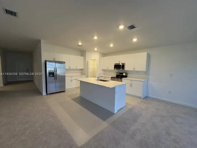 a large kitchen with cabinets and stainless steel appliances