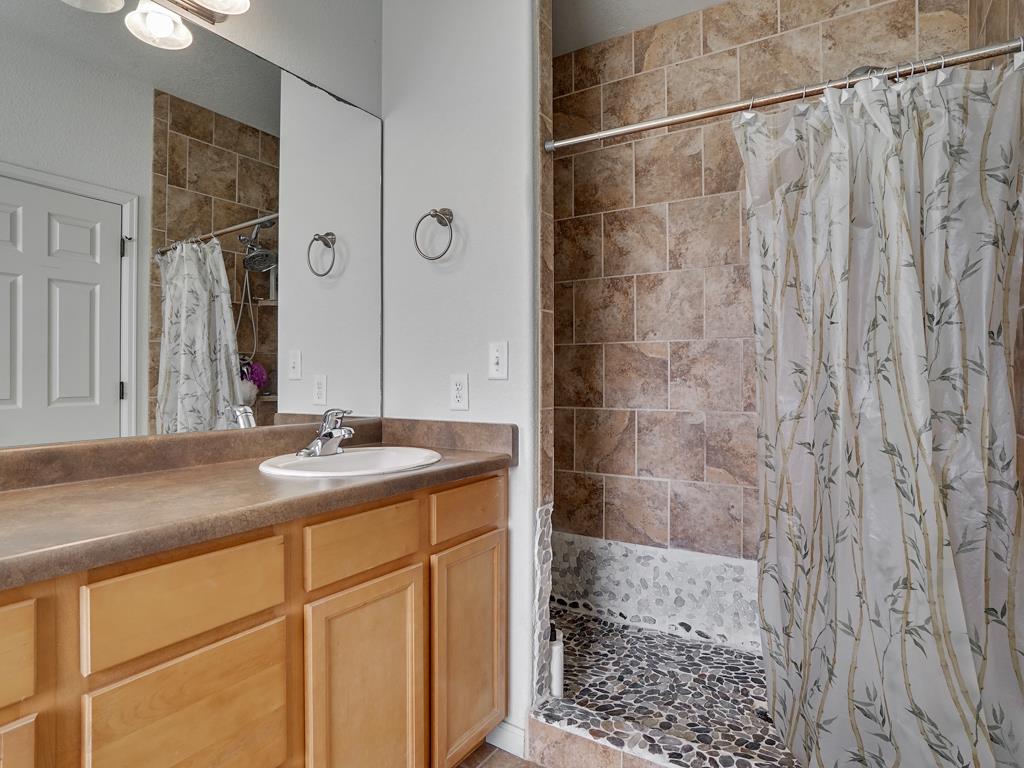 1853 Golden Ranch Road Fruita, CO 81521 - Photo 15 of 30 a bathroom with a granite countertop sink a mirror and shower