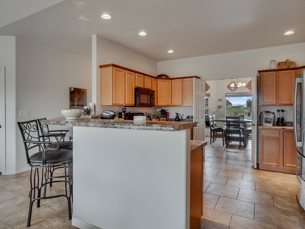1853 Golden Ranch Road Fruita, CO 81521 - Photo 7 of 30 a kitchen with a table chairs microwave and cabinets
