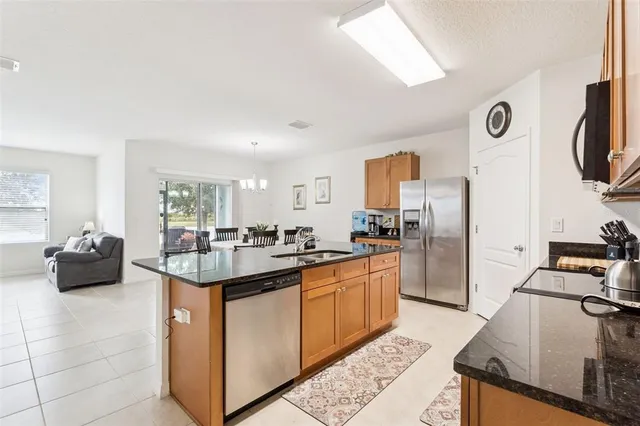 a kitchen with stainless steel appliances granite countertop a sink and a refrigerator