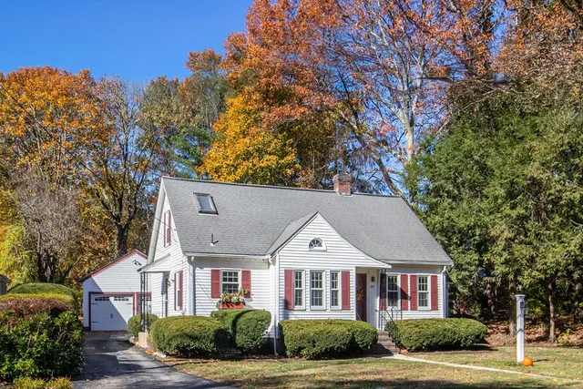 a view of a big house with large tree and plants