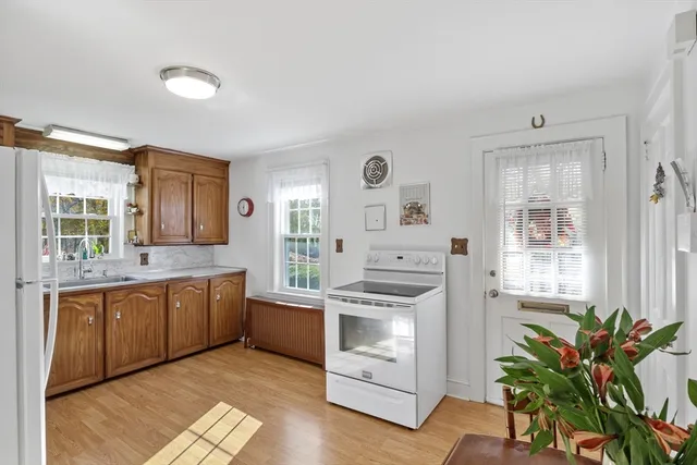 a kitchen with granite countertop white cabinets and white appliances