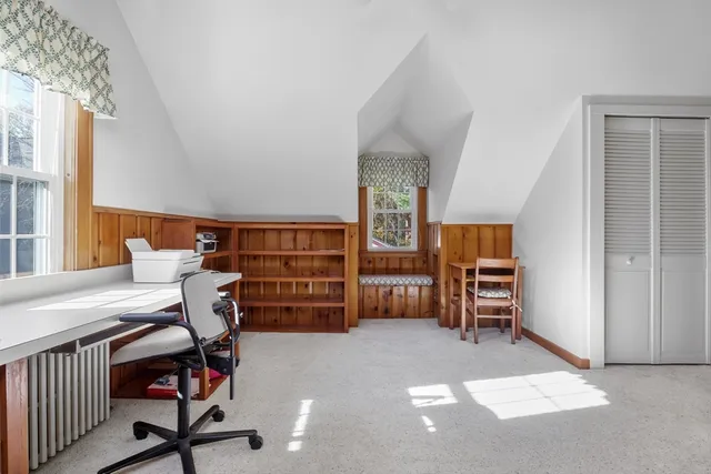 a view of a workspace with furniture and a window