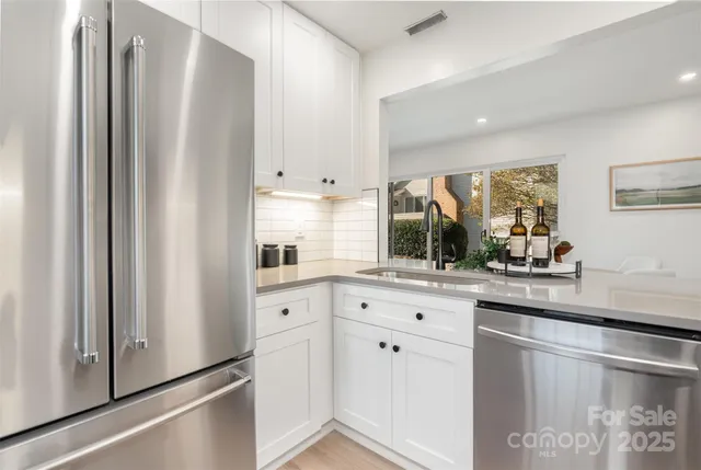 a kitchen with stainless steel appliances a sink microwave and cabinets