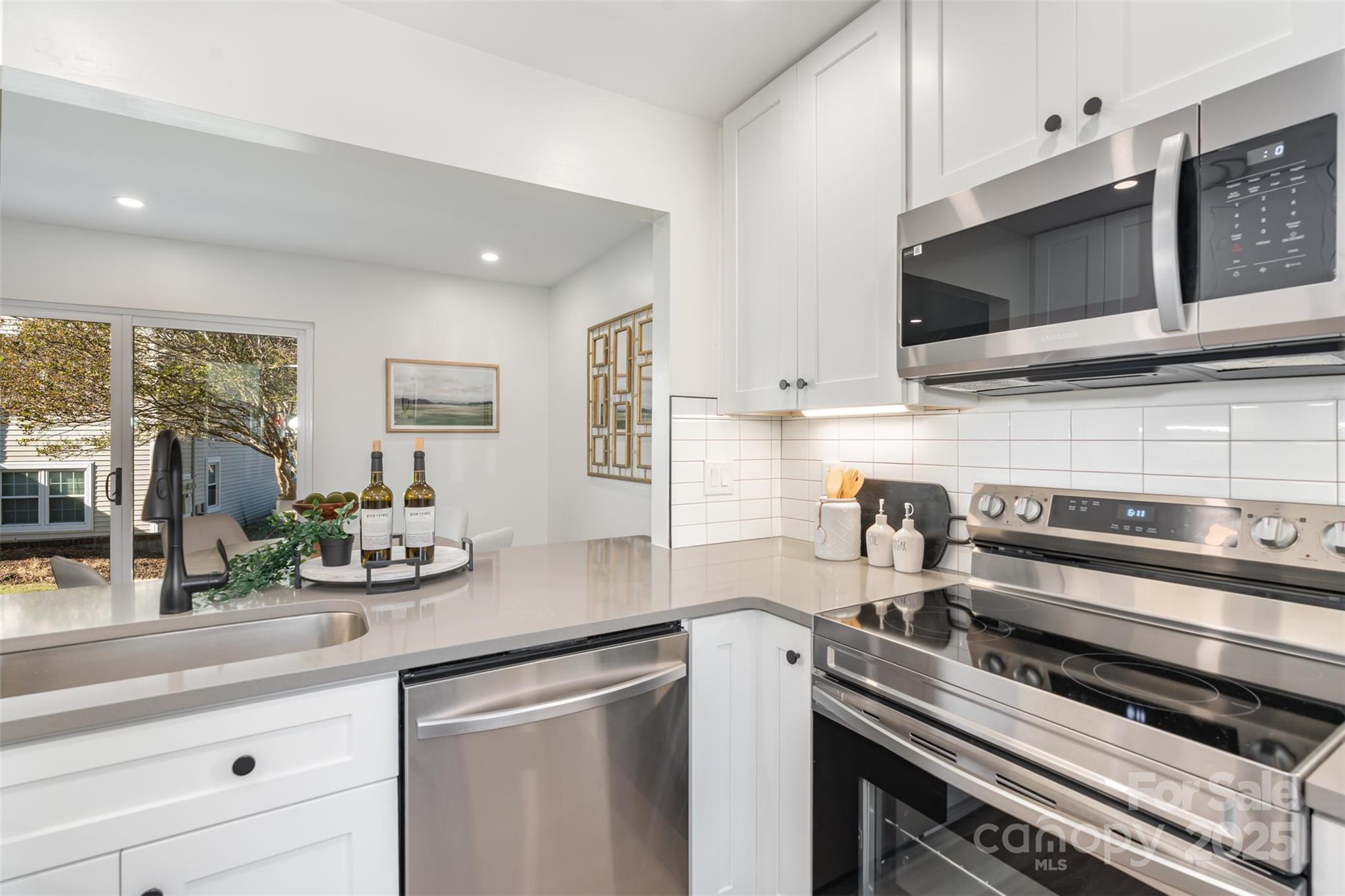 7802 Renaissance Court, Unit B Charlotte, NC 28226 - Photo 12 of 22 a kitchen with stainless steel appliances a sink microwave and cabinets
