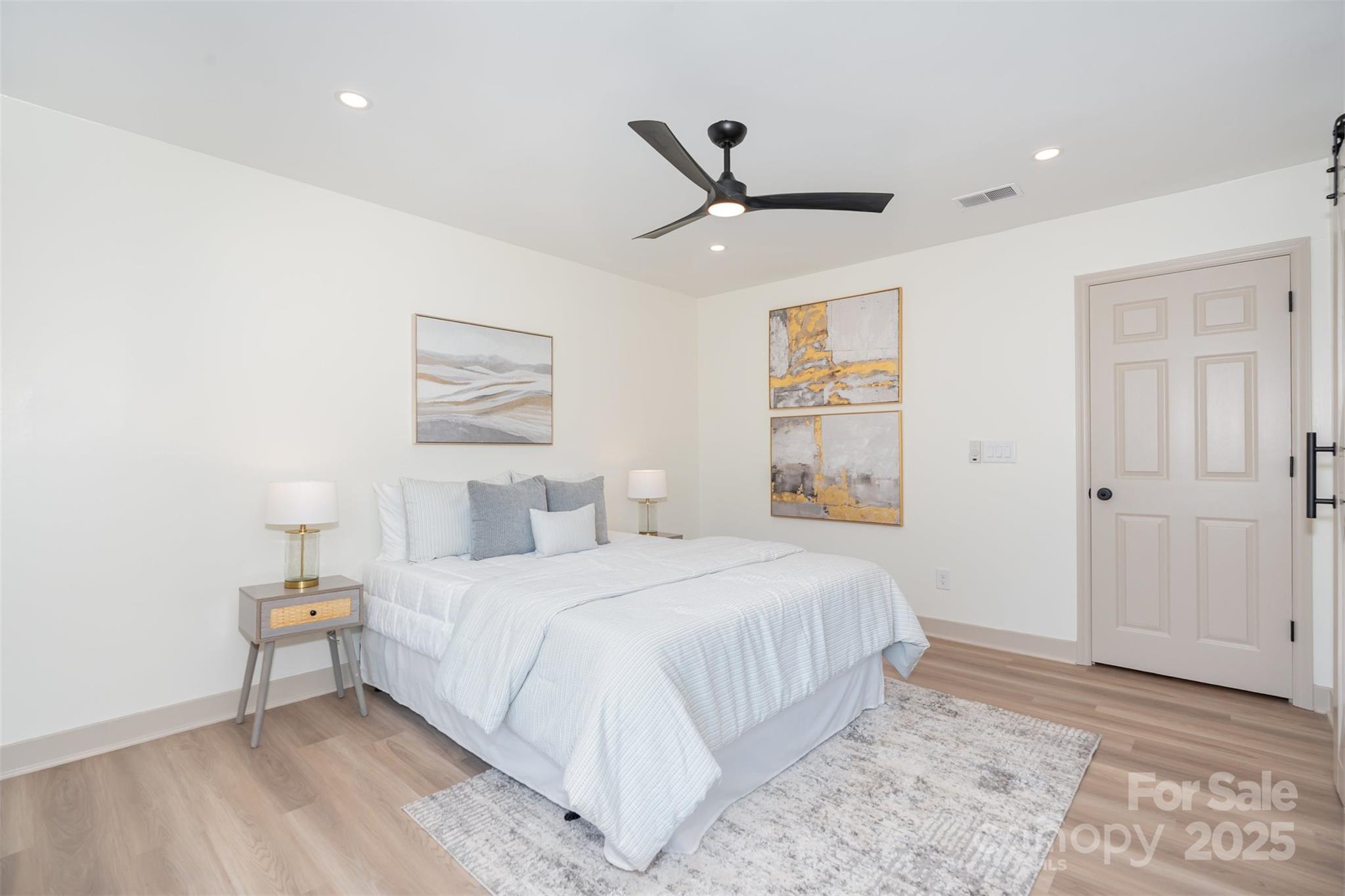 7802 Renaissance Court, Unit B Charlotte, NC 28226 - Photo 14 of 22 a bedroom with a large bed and a ceiling fan