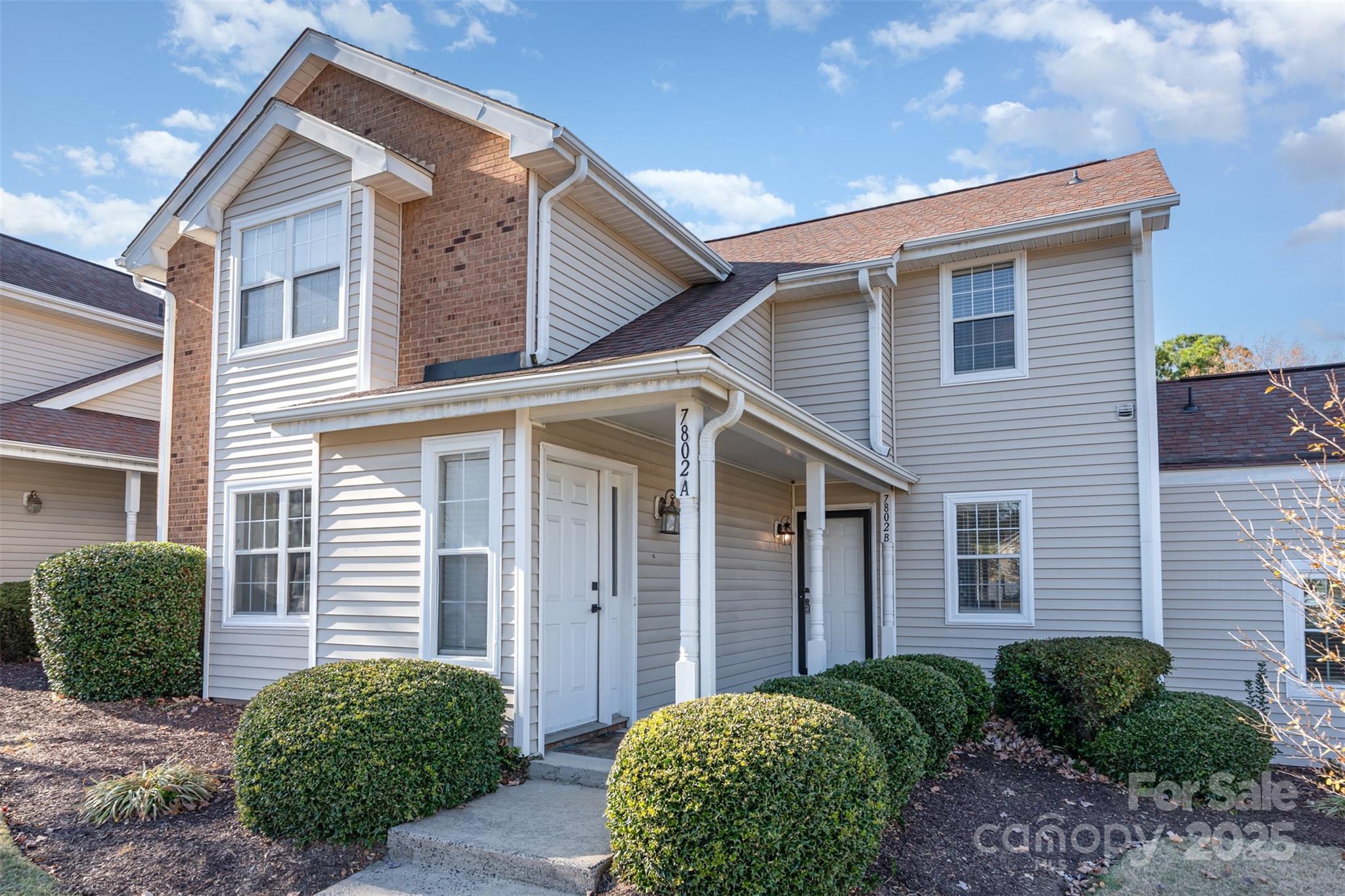 7802 Renaissance Court, Unit B Charlotte, NC 28226 - Photo 3 of 22 a view of a house with brick walls and a yard