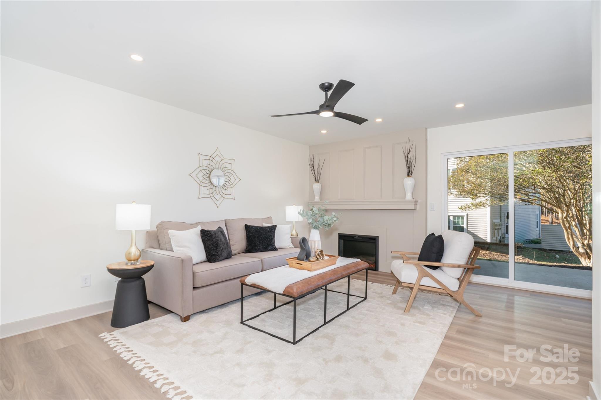 7802 Renaissance Court, Unit B Charlotte, NC 28226 - Photo 5 of 22 a living room with furniture a fireplace and a floor to ceiling window