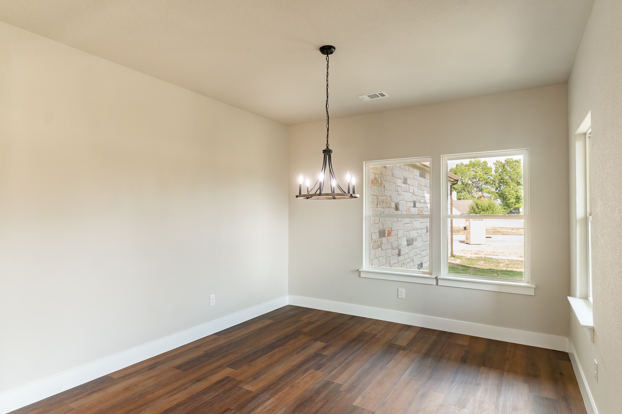 305 String Prairie Way Smithville, TX 78957 - Photo 10 of 26 a view of a room with wooden floor exposed radiator and windows
