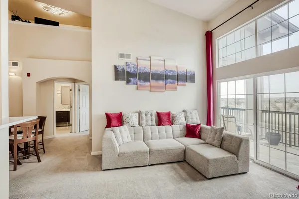 a living room with furniture and a floor to ceiling window