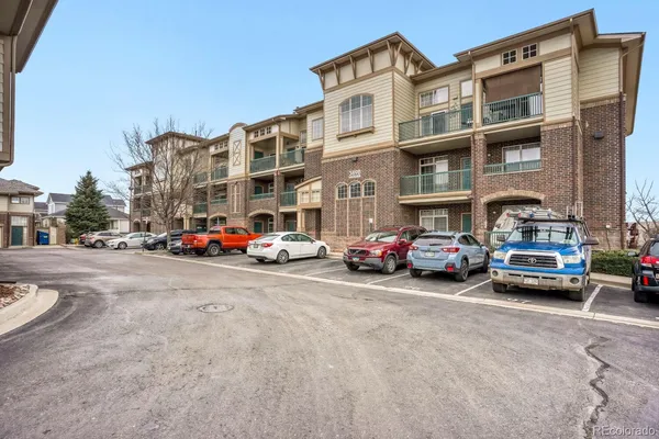 a front view of building with cars parked