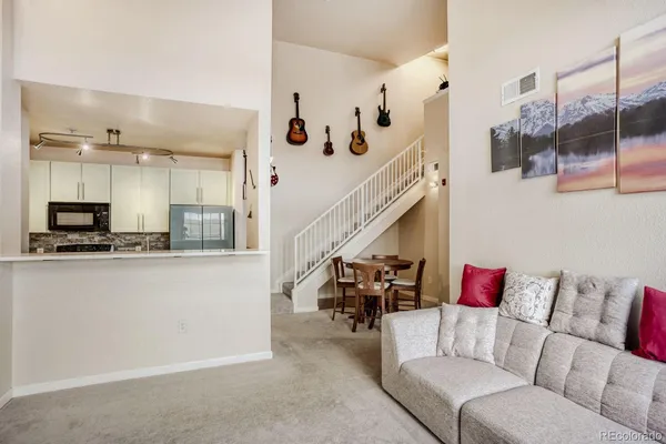 a living room with furniture and kitchen view