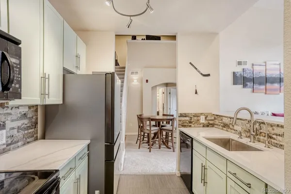 a kitchen with a sink refrigerator and cabinets