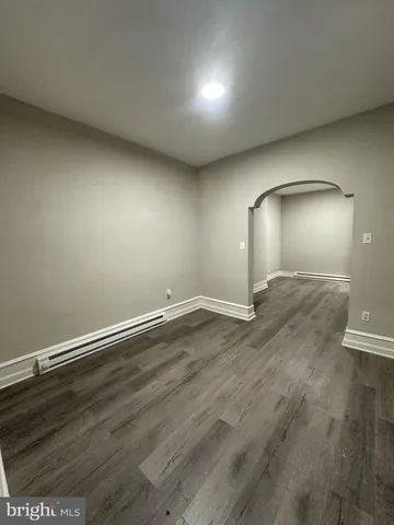 an empty room with wooden floor and mirror