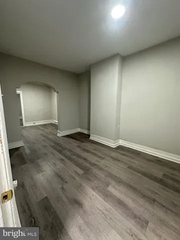 an empty room with wooden floor and mirror