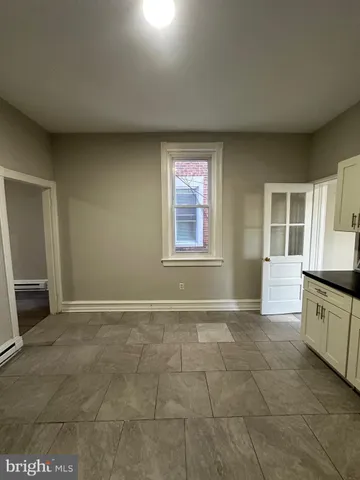 a view of an empty room with a kitchen