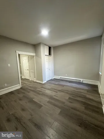 an empty room with wooden floor and window