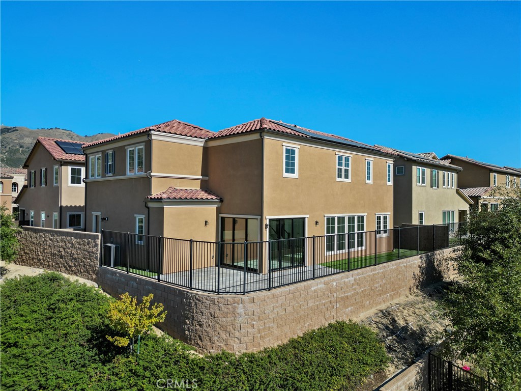 20828 Bur Oak Circle Porter Ranch, CA 91326 - Photo 35 of 43 a view of a white house with large windows and a small yard