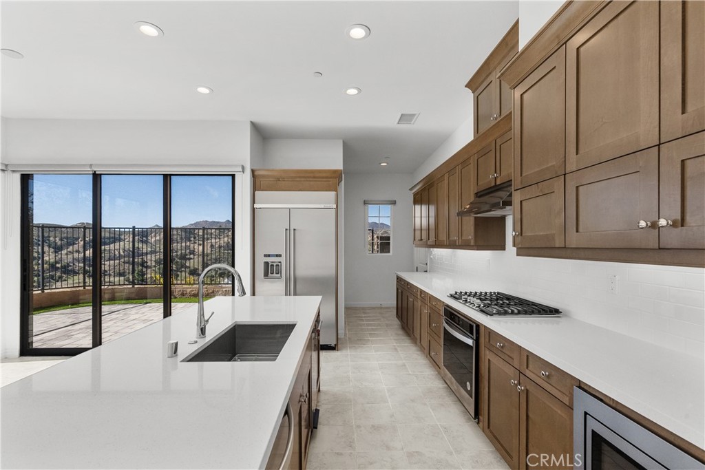20828 Bur Oak Circle Porter Ranch, CA 91326 - Photo 10 of 43 a kitchen with stainless steel appliances a stove a sink and a refrigerator