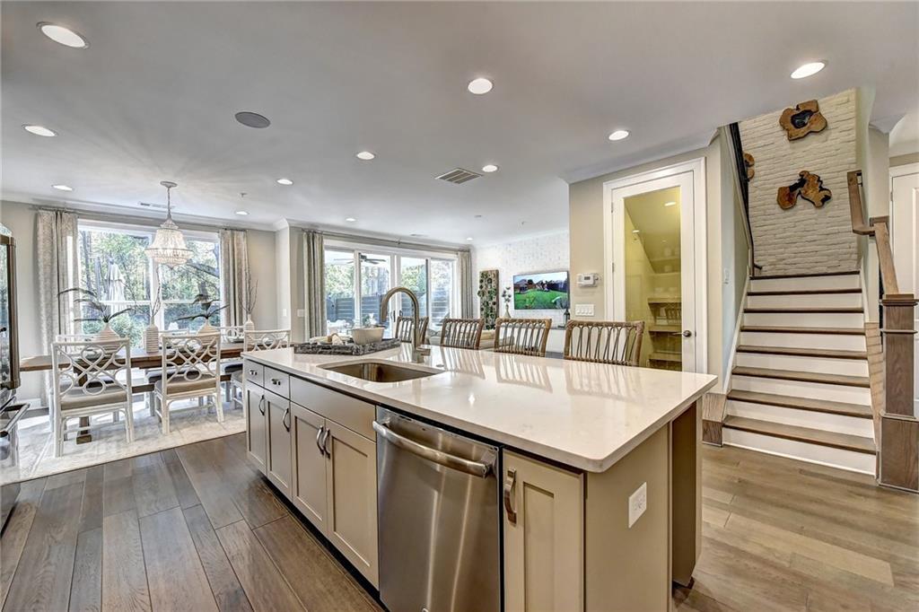 a large white kitchen with a large window and stainless steel appliances